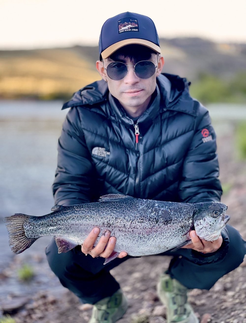 Angler with a rainbow trout at the Alicurá Reservoir