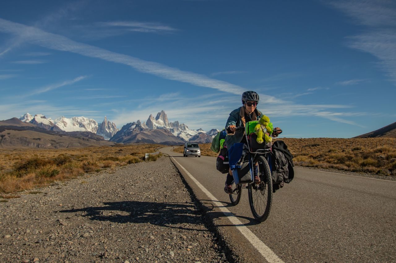 Ciclista con alforjas en la Ruta 40, con el cerro Fitz Roy al fondo, cerca de El Chaltén